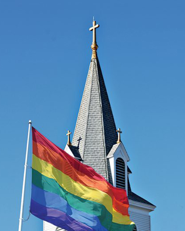 Image of a church with a rainbow Pride flag hanging outside